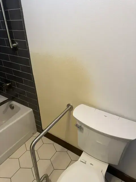 Finished textured drywall above a tub surround in a remodeled bathroom