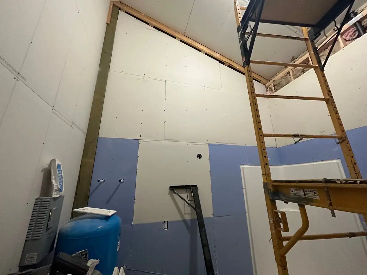 Scaffold in a tall utility room with board hung up to the roof line
