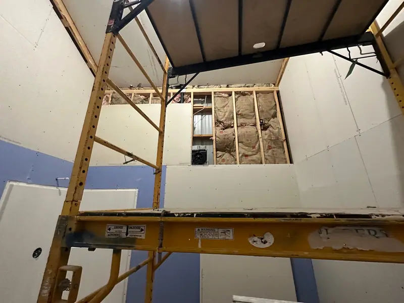 Scaffold set up under a vaulted ceiling while the drywall goes up