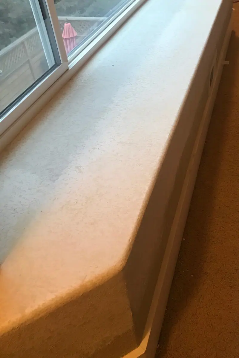 The same bay-window plant shelf wrapped in drywall, textured and painted