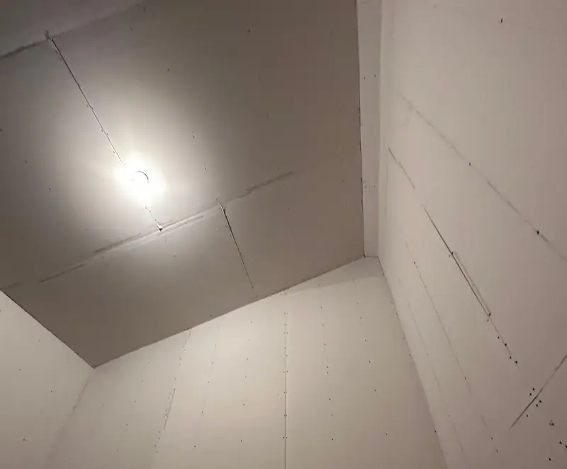 Upper walls and ceiling of a pole barn room hung in drywall