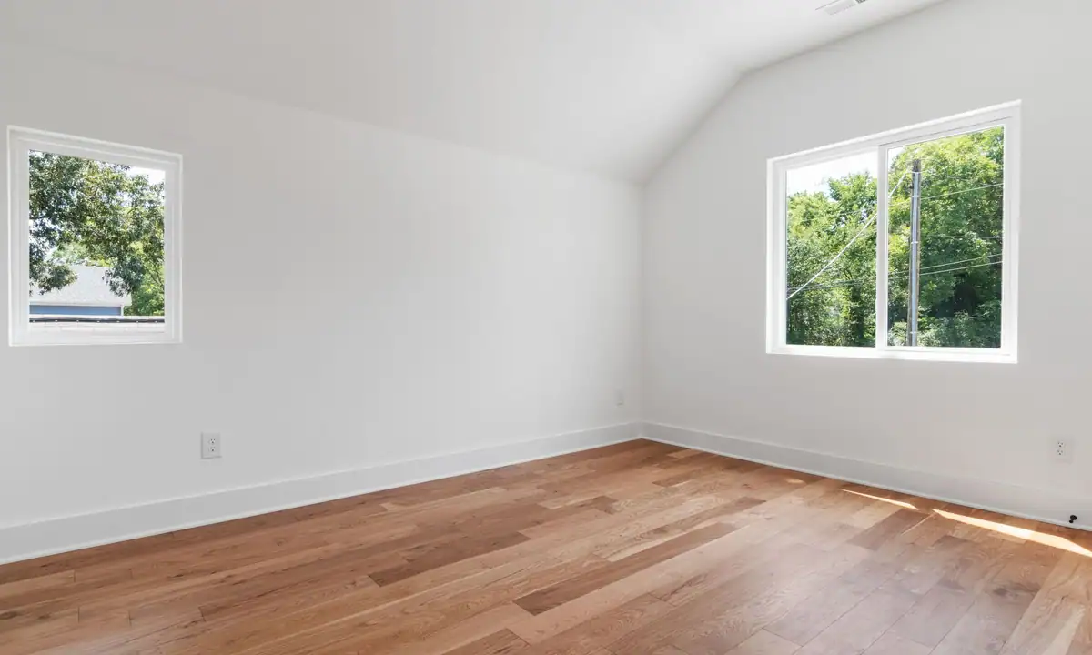 Bright empty room with a sloped ceiling and smooth white walls