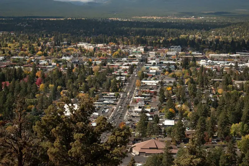 View west over Bend, Oregon from Pilot Butte, with autumn street trees and the Cascade foothills behind